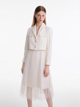A lady wears a white tulle skirt.